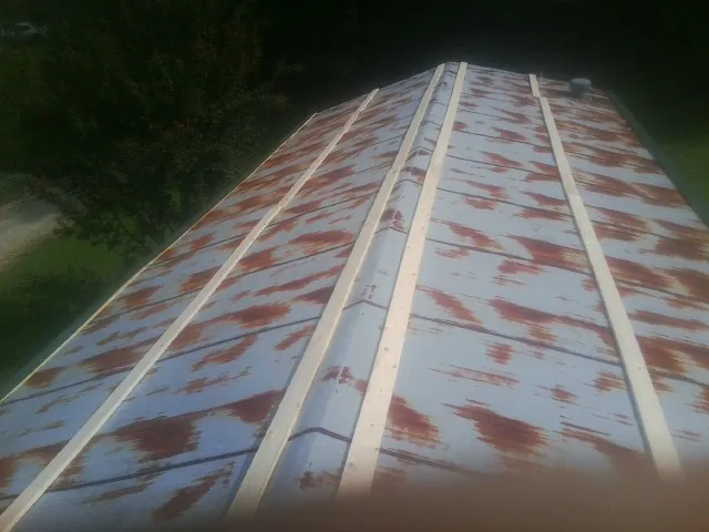 Rusted metal roof panels with new wood purlins before replacement — Storm Damage Roof Repair in Moody by Roofing Brothers